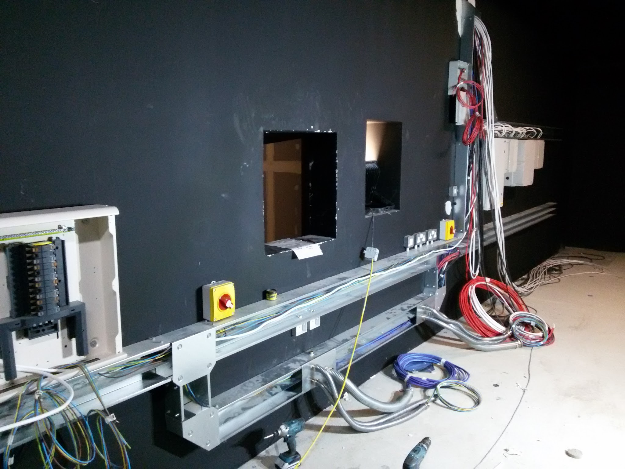 Trunking, an isolator and distribution boards being wired on a black wall